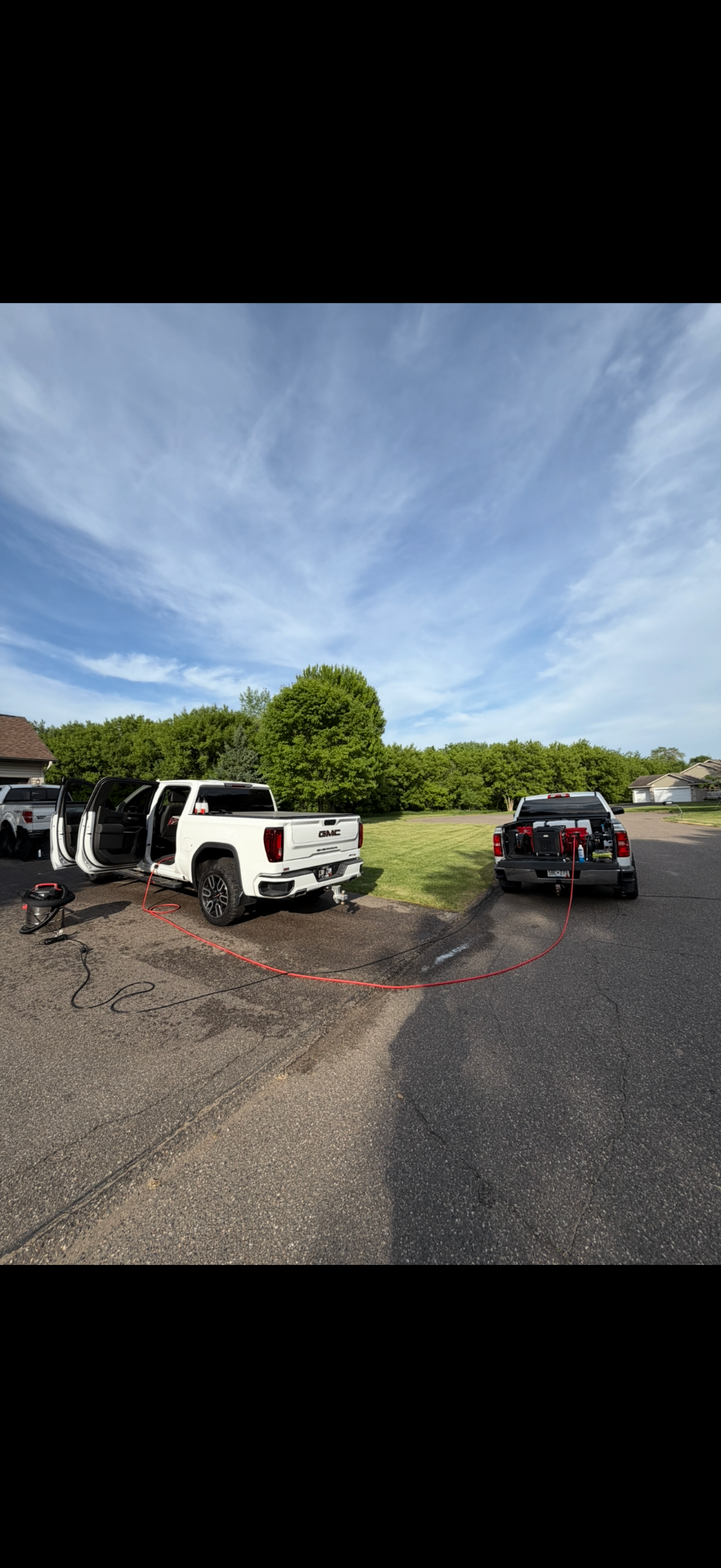 Mobile detailing setup with truck and trailer at a customer location
